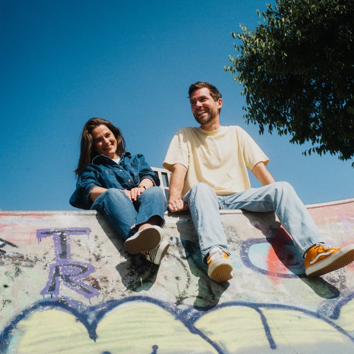 Agenturerfahrung Andrea Engel hängt kopfüber an einem Spielgerät, Frank Röhrig steht lässig daneben.